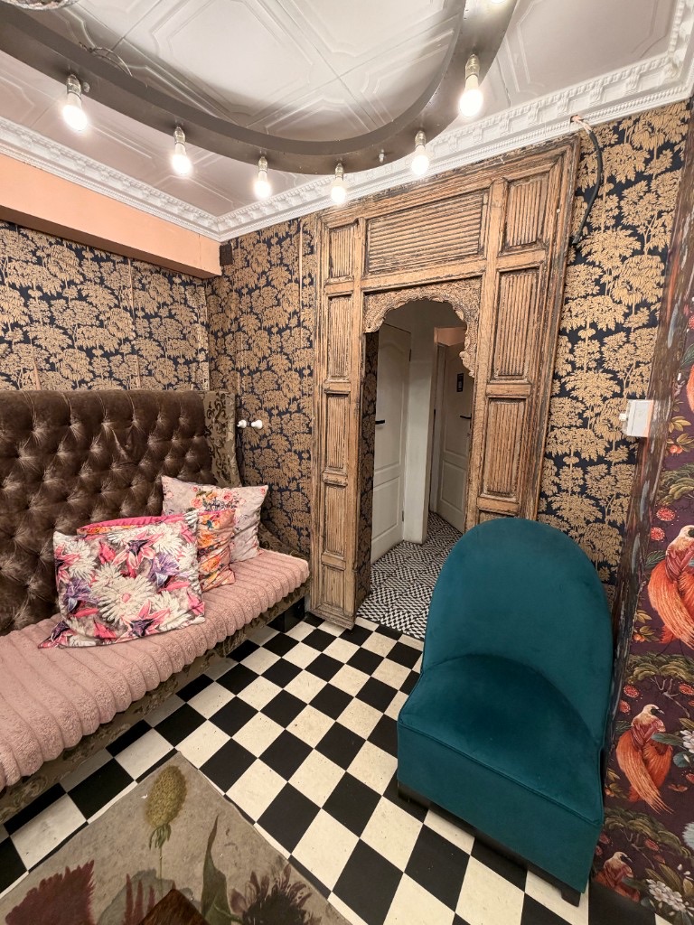 Gold wallpaper lounge with teal armchair