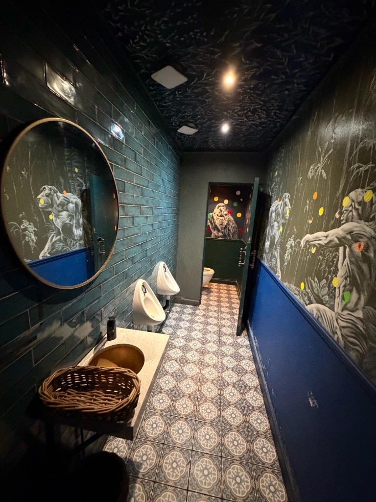 Men's restroom with primate mural