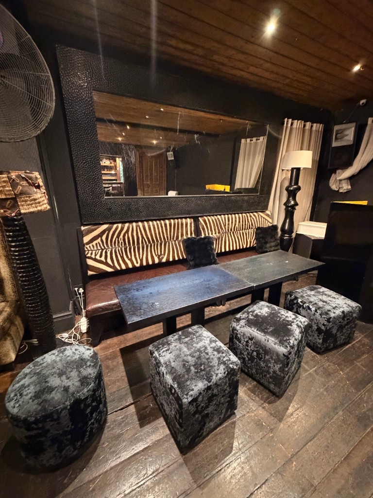 Zebra-print lounge with velvet ottomans