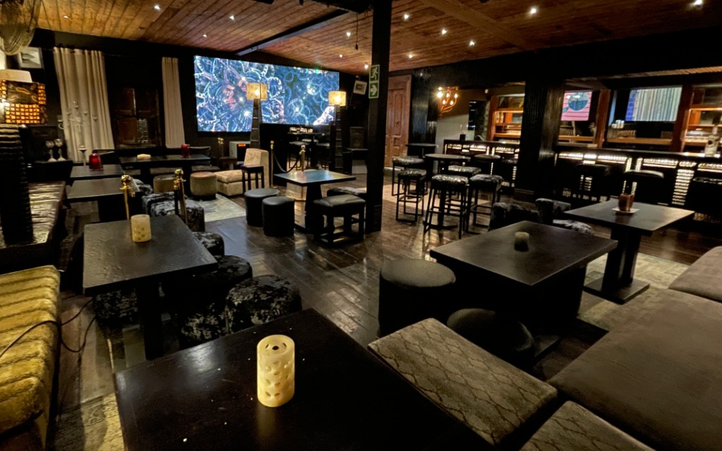 The Opium Lounge main floor — velvet seating, candlelit tables and LED wall